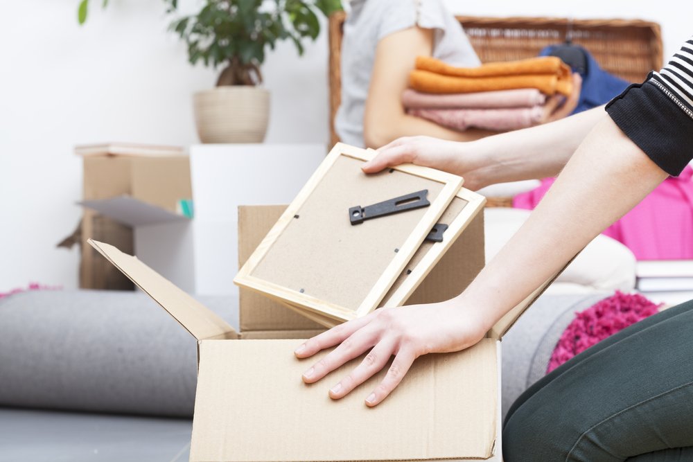 Close up of womans hand packing two photo frames